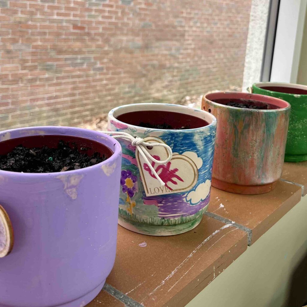 Hand-painted flower pots sit on a windowsill at Room in the Inn - Memphis