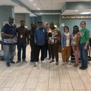 Photo of guest, Rick, with RITI staff and his stepson, Elton, as Rick departs for his new home.